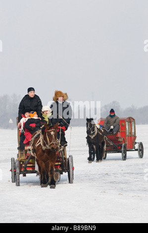 Carrozze trainate da cavalli attraversano il congelato fiume Songhua Harbin, Heilongjiang Cina 2009 Foto Stock