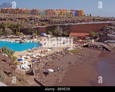 Case colorate in cima alla scogliera con spiaggia in primo piano a Playa Parasio, Costa Adeje, Tenerife. Foto Stock