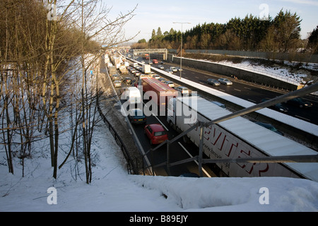 Automobili Autocarri M25 Autostrada traffico neve invernale di inceppamento Foto Stock