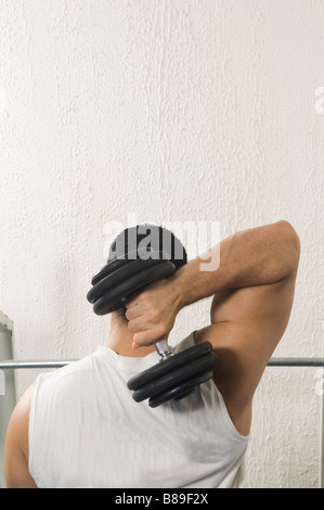 Uomo libero sollevamento peso manubrio in palestra Foto Stock