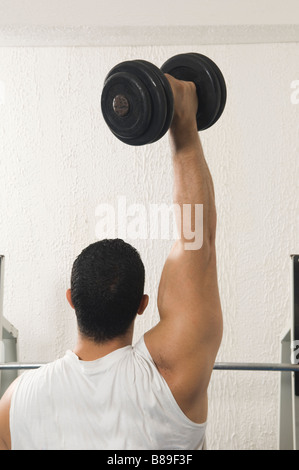 Uomo libero sollevamento peso manubrio in palestra Foto Stock