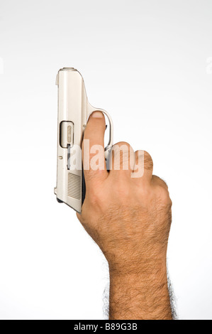 Stretta di mano che tiene una pistola Foto Stock