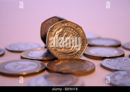 Una fotografia del NHS cinquanta pence pezzo circondato da due libbre di monete e altri UK GBP denaro Foto Stock