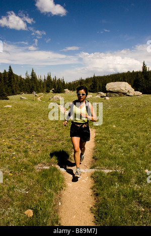 Donne trail running nel Parco Nazionale delle Montagne Rocciose eseguire sul sentiero di ritorno dal lago perduto area. Foto Stock