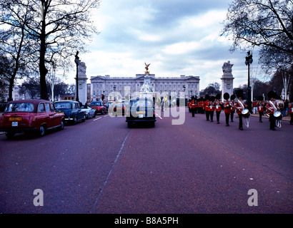 Queens guardie marzo da Buckingham Palace lungo il centro commerciale Foto Stock