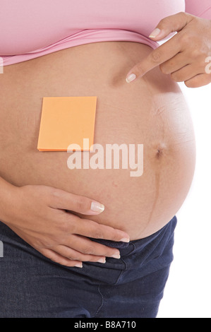 Foto di un anonimo donna incinta a su sfondo bianco Foto Stock