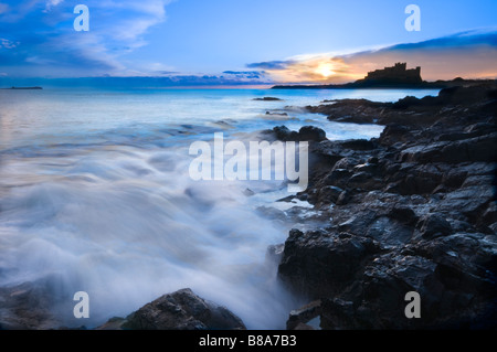 In inverno l'alba sopra il famoso castello di Bamburgh sulla costa nord est dell' Inghilterra Foto Stock