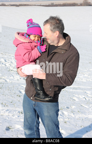 Figlia di padre bianco figlia toddlerl etnica nero razza mista sorridenti divertirsi giocando a snow ice giovani Foto Stock