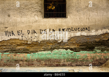 Parete testurizzata a Quetzaltenango Highlands Occidentali Guatemala con graffiti "Viva el dia de la Revolucion' Foto Stock