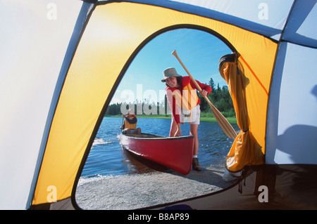 FV3302, Dave Reede; coppia di entrare in canoa, visto attraverso porta tenda, Whiteshell PP, Manitoba Foto Stock