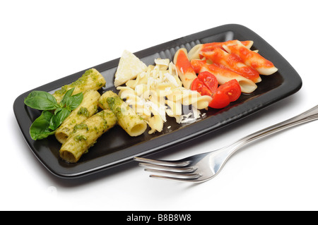 Tipica pasta italiana disposte con la bandiera dell'Italia i colori e gli ingredienti tipici pesto grana e pomodoro Foto Stock