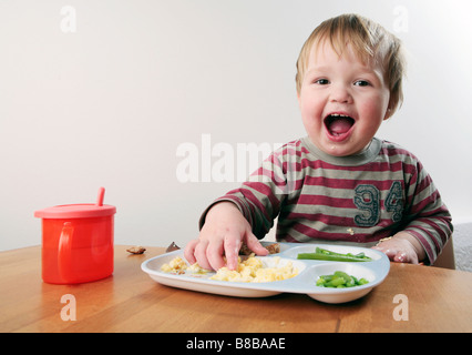 Baby boy di mangiare al tavolo (con firmato modello di rilascio - disponibile per uso commerciale) Foto Stock