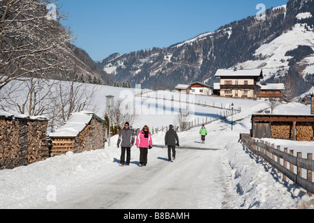 Vale la pena di Rauriser Sonnen Valley Austria le persone camminare su Winterwanderweg cancellato il sentiero lungo la valle alpina in inverno la neve Foto Stock