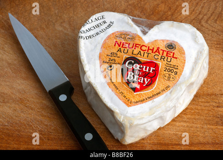 Francese a forma di cuore Neufchatel / Normandy fresco formaggio morbido su legno tagliere. Foto Stock