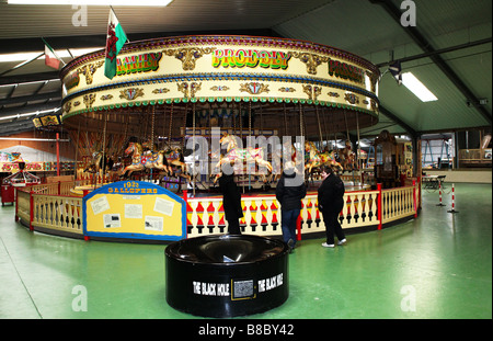 In legno tradizionali Merry Go Round fiera Cavalcata Cavallo al galoppo giostra all'interno grande magazzino UK Foto Stock