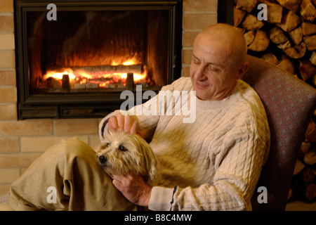 Uomo e cane a un caminetto Foto Stock