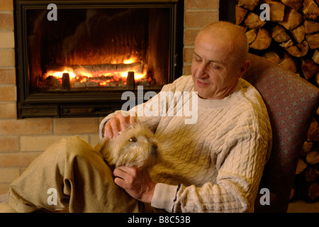 Uomo e cane a un caminetto Foto Stock