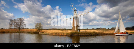 Un tradizionale in legno barca a vela vela nella parte anteriore del fondo erboso Fen mulino sul fiume Ant Norfolk Broads Foto Stock