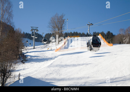 Zell am See Austria UE gennaio sciatori andando fino alla parte superiore della pista da sci in City Express gondola cabine Foto Stock