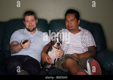 Coppia gay guardando la TV Boston Terrier Foto Stock