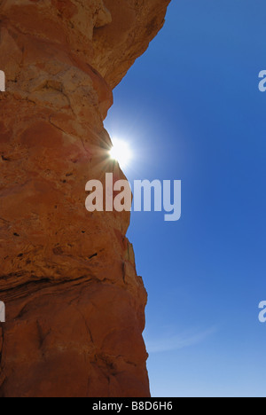 Sun e i raggi peeking oltre il bordo della roccia arenaria monolito a Kodachrome basin parco dello stato dello Utah Foto Stock