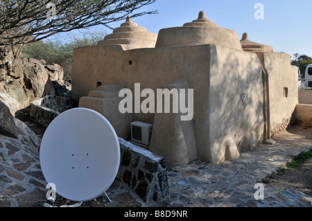 L'emirato della moschea storica più antica di Fujairah negli Emirati Arabi Uniti a Badiyah, con moderno impianto di aria condizionata e servizi di antenna parabolica adiacenti Foto Stock