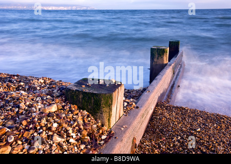 Mare di legno Groyne a Keyhaven, con l'Isola di Wight in distanza. Foto Stock