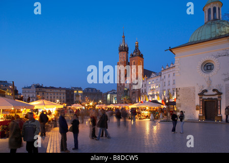 La piazza principale del mercato Rynek Glowny con la Chiesa di Wojciech destra e la chiesa di Santa Maria al crepuscolo Cracovia Cracovia Polonia Foto Stock