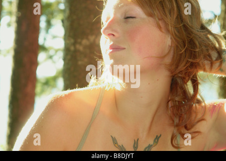 Donna con gli occhi chiusi nel boschetto di alberi, Equitazione Mountain National Park, Manitoba, Canada Foto Stock