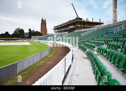 Righe di sedi vuote al Somerset cricket club Taunton Inghilterra con costruzione in corso in background Foto Stock