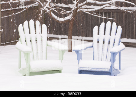 Adirondack sedie in un cortile suburbana durante una tempesta di neve Foto Stock