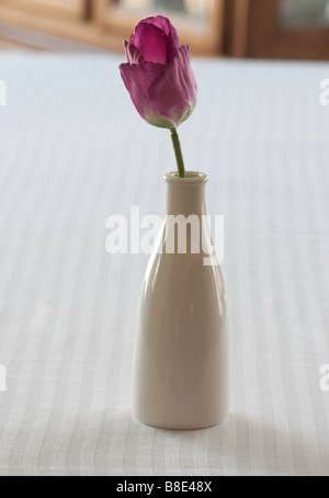 Un tulipano artificiale in un vaso bianco Foto Stock