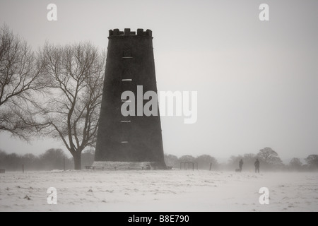 Dog walkers accanto al mulino di nero su una coperta di neve westwood comuni di Beverley East Yorkshire Regno Unito Foto Stock