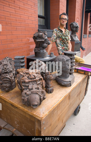 Un arte di strada venditore in Milwaukee è storico terzo Ward durante l estate Galleria notte Foto Stock