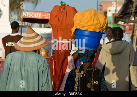 Le donne che trasportano fasci bilanciato sulle loro teste a St Louis in Senegal Africa occidentale Foto Stock