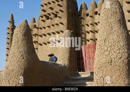 Workman presso la Grande Moschea di Djenne Mali in Africa occidentale Foto Stock