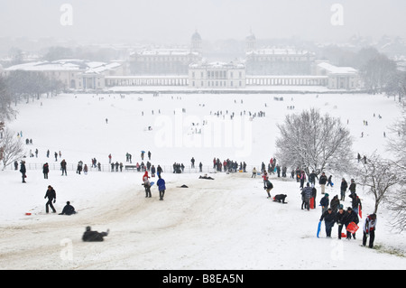 Persone in Greenwich Park gode di una forte nevicata la costruzione di pupazzi di neve e slittino. Foto Stock