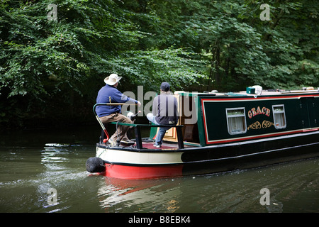 Due uomini sterzare una stretta barca lungo la Bridgewater Canal Foto Stock