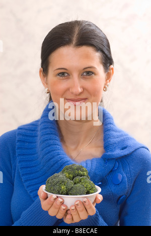 Donna che mantiene una ciotola di verdure broccoli Foto Stock