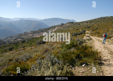 Donna escursionismo sulla pista di montagna, vicino a Benimaurell, Vall de Laguar, provincia di Alicante, Comunidad Valenciana, Spagna Foto Stock