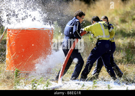 Vigili del fuoco riempire il monsone bucket di un elicottero di combattimento bushfire in Nuova Zelanda Foto Stock