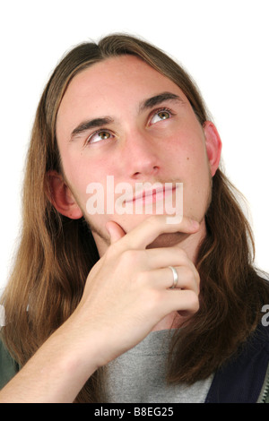 Fine teen maschio con capelli lunghi pensando a qualcosa di Foto Stock