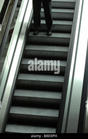 Gambe su di una scala mobile in un centro commerciale Foto Stock