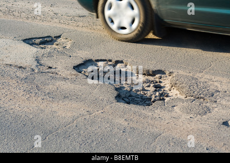 Asfalto s fori sul fondo stradale in auto moto Foto Stock