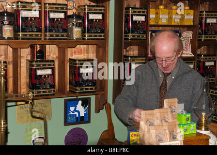Vari tè in vendita in uno specialista tea shop store a Lavenham,Suffolk,Uk con il proprietario del negozio dietro il contatore Foto Stock