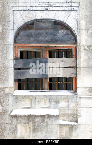 Vecchio edificio sul telaio di una finestra bloccata con assi di legno. Foto Stock