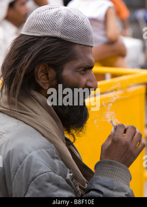 Musulmani uomo indiano in zucchetto, fumatori; Delhi, India Foto Stock