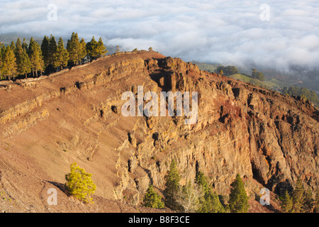 La vista dal cratere sopra a Pinos de Galdar poco dopo l'alba. Strato di nubi sulle colline di seguito. Gran Canaria Isole Canarie. Foto Stock