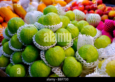 Fresh guaiave avvolto in polistirolo sul display tra altre frutta Foto Stock