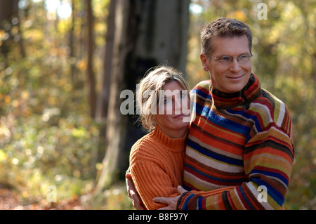 Adulti metà donna e uomo che abbraccia ogni altra in un parco Foto Stock
